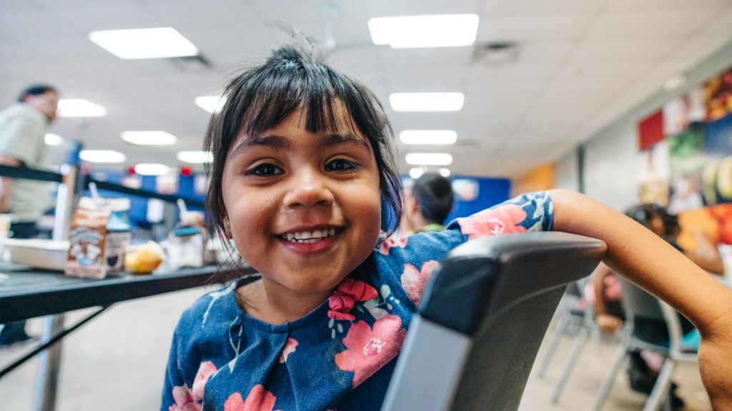 Smiling girl in cafeteria