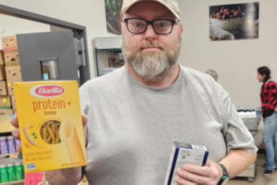 Bobby selects protein pasta while shopping at Pella Food Shelf